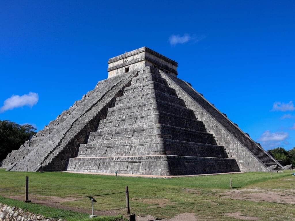 Die majestätische Pyramide El Castillo, auch Tempel des Kukulcán genannt, als weltberühmtes Wahrzeichen der Maya-Stätte Chichén Itzá in Mexiko unter strahlend blauem Himmel