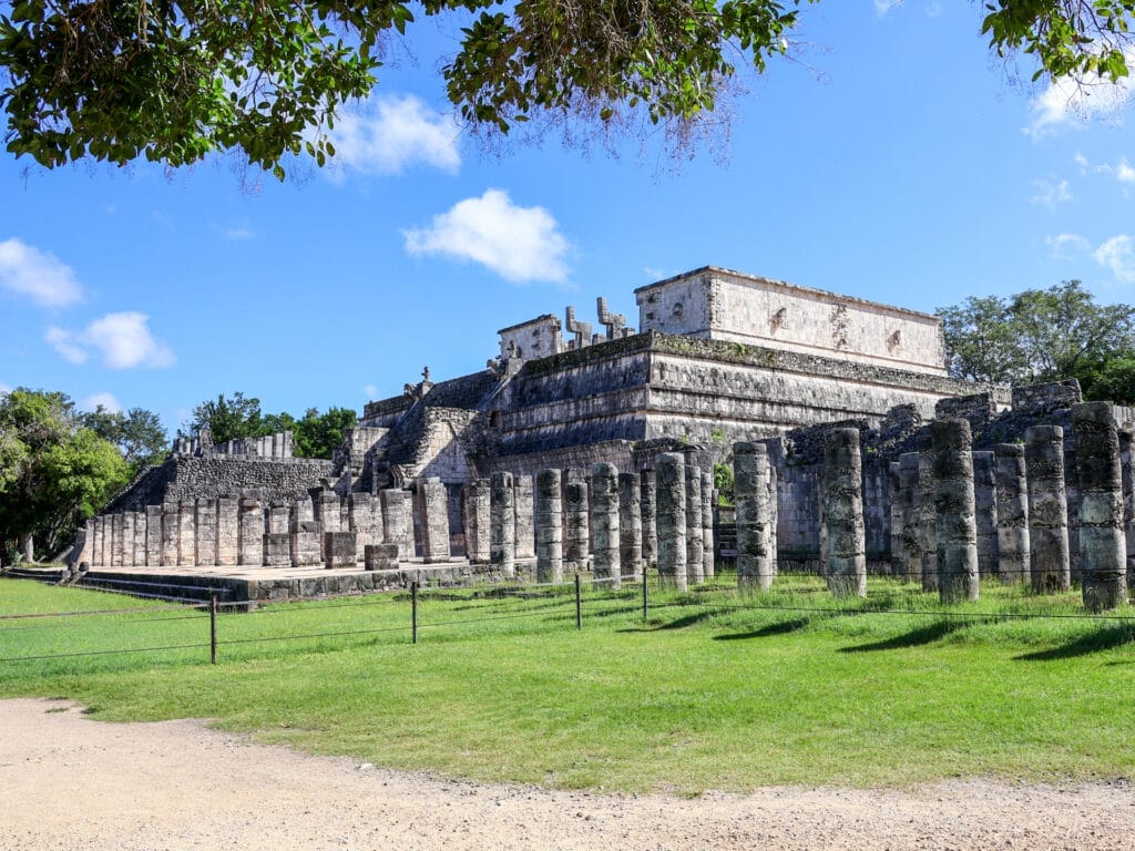 Tempel der Krieger und die Halle der tausend Säulen in der berühmten Maya-Stätte Chichén Itzá in Mexiko unter strahlend blauem Himmel