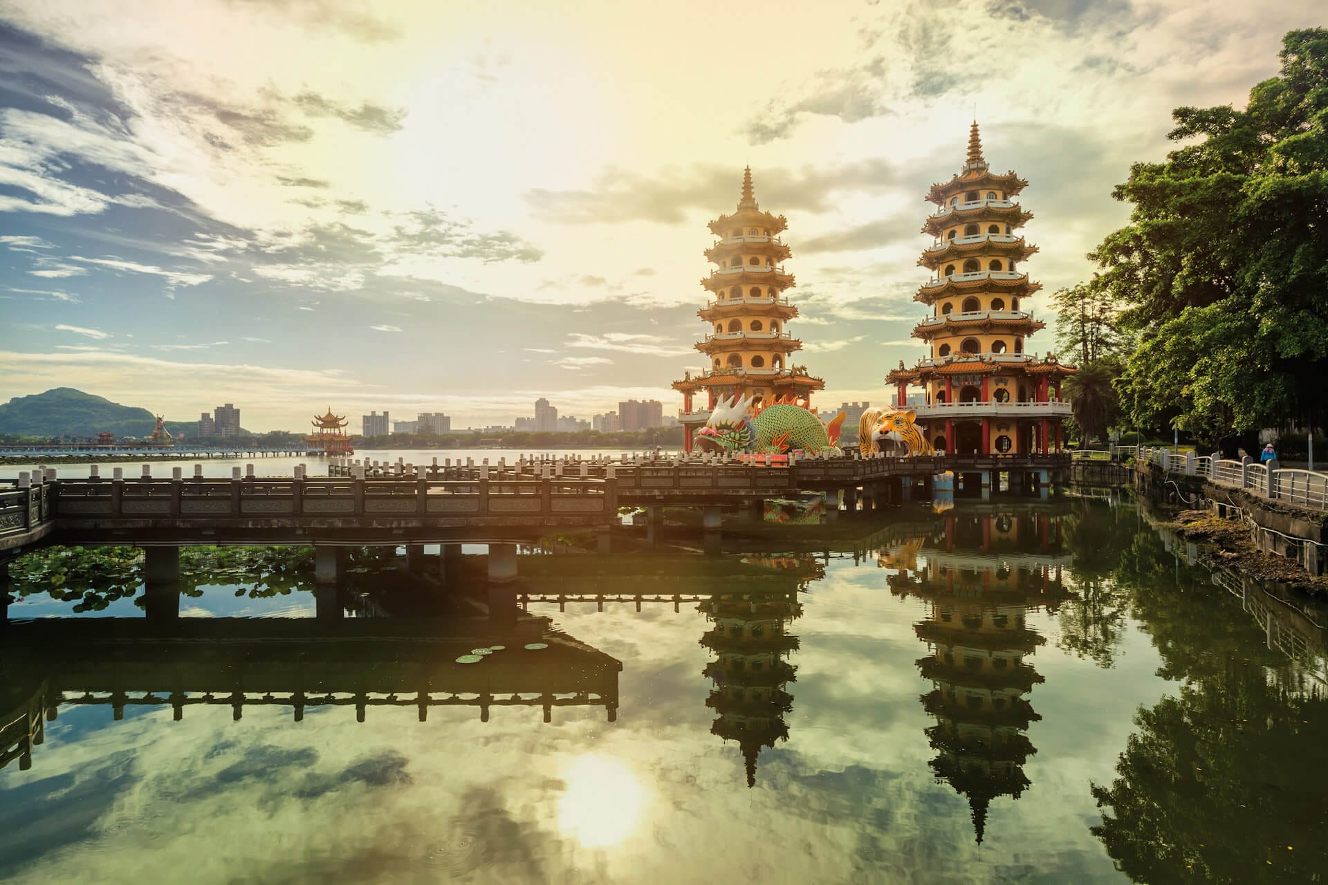 Malerischer Sonnenuntergang bei den Drachen- und Tiger-Pagoden am Lotus-See in Kaohsiung, Taiwan. Die beiden Pagoden und der Himmel spiegeln sich im ruhigen Wasser.